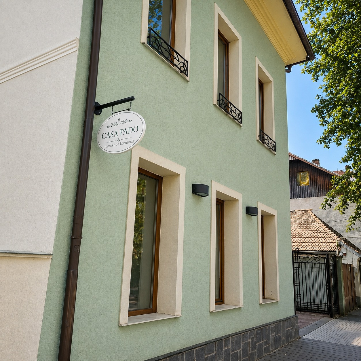 Fațada verde a Casei Pado cu firma pe stradă